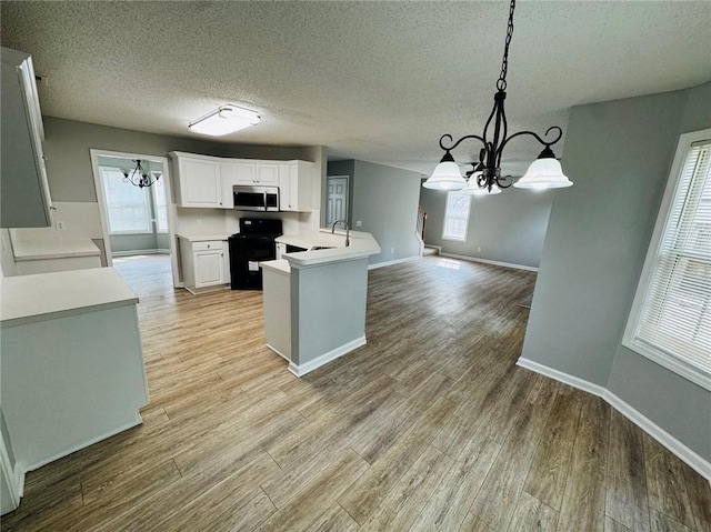108 Northcutt Station Pl, Acworth, GA 30101 - kitchen with a chandelier, stainless steel microwave, black electric range oven, baseboards, and a textured ceiling