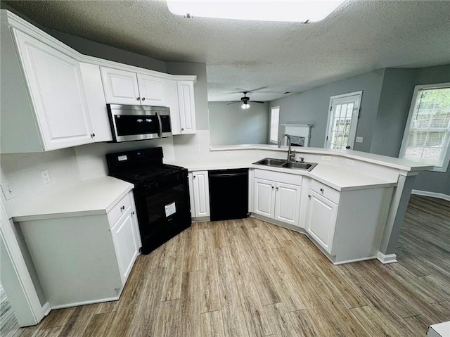108 Northcutt Station Pl, Acworth, GA 30101 - kitchen featuring black appliances, a peninsula, a sink, light wood-style flooring, and a textured ceiling