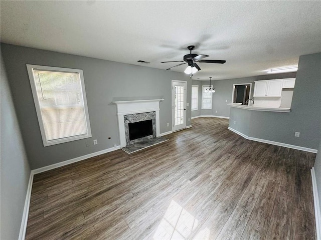 108 Northcutt Station Pl, Acworth, GA 30101 - unfurnished living room featuring wood finished floors, a fireplace, a ceiling fan, baseboards, and a sink