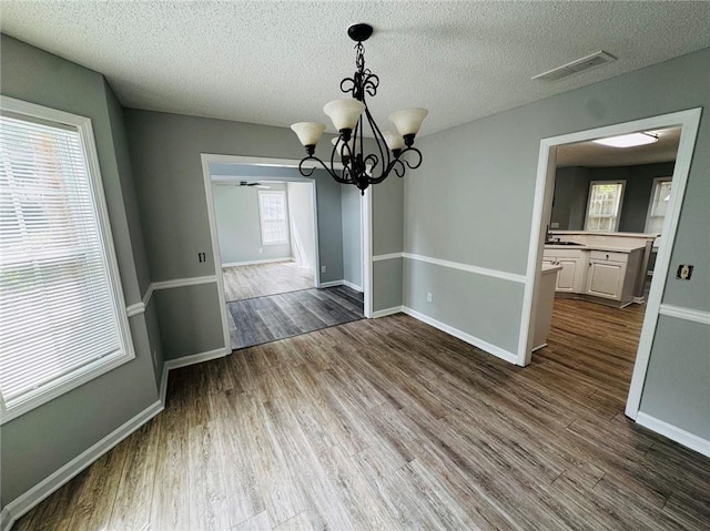 108 Northcutt Station Pl, Acworth, GA 30101 - unfurnished dining area with dark wood-style floors, a chandelier, a textured ceiling, and baseboards