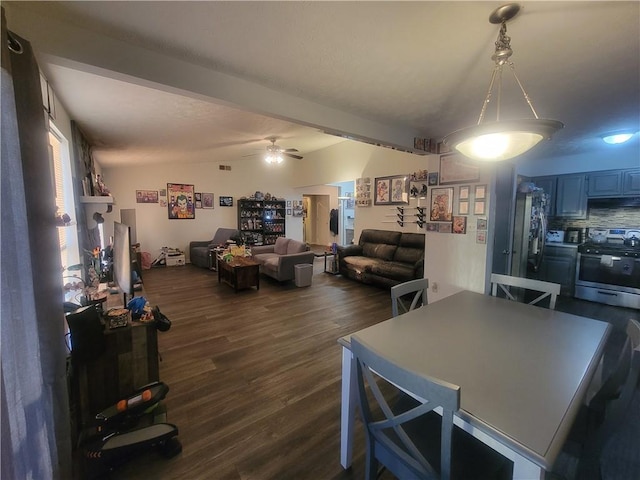 dining space featuring lofted ceiling with beams, dark wood-type flooring, and a ceiling fan