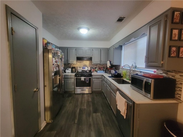 kitchen featuring backsplash, appliances with stainless steel finishes, sink, and gray cabinetry