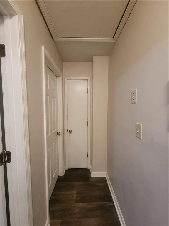 corridor featuring baseboards and dark wood-style flooring