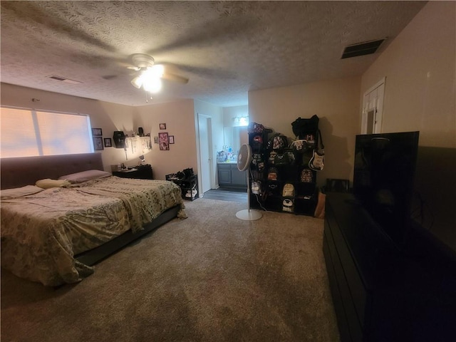 bedroom featuring ceiling fan, ensuite bath, and a textured ceiling