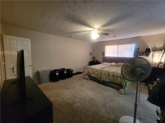 carpeted bedroom with ceiling fan and a textured ceiling