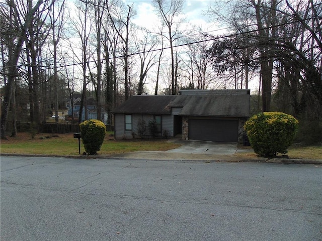 view of front of property featuring stone siding, a garage, and driveway