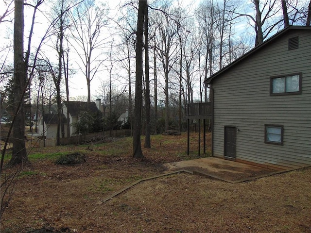 view of yard with a wooden deck and a patio area