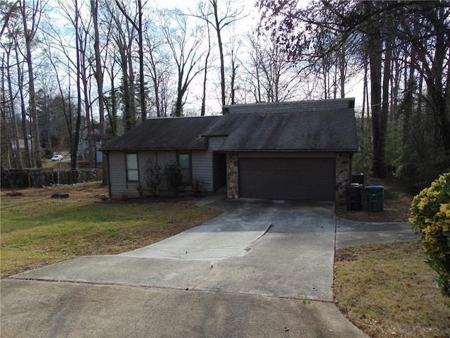 view of front of house with concrete driveway, a front yard, roof with shingles, stone siding, and an attached garage