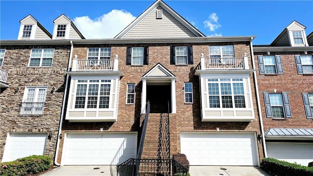 townhome / multi-family property with an attached garage, driveway, and brick siding