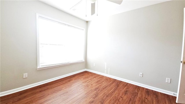 spare room featuring a ceiling fan, baseboards, and wood finished floors