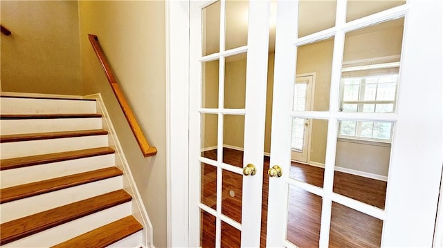 stairs featuring french doors and wood finished floors