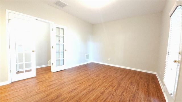 unfurnished room with baseboards, light wood-type flooring, and visible vents