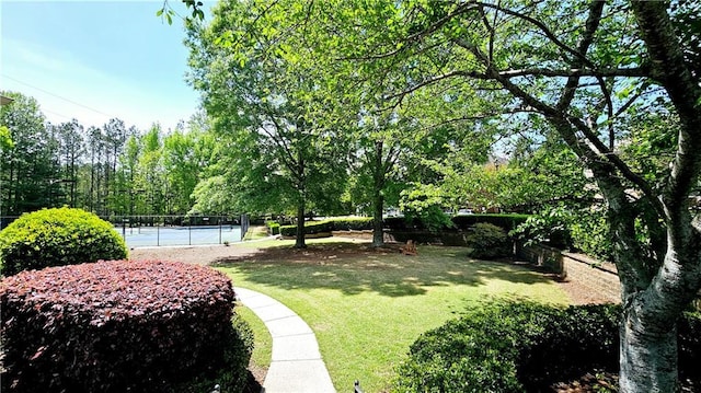 view of yard featuring fence and a tennis court