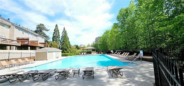 community pool featuring fence and a patio area