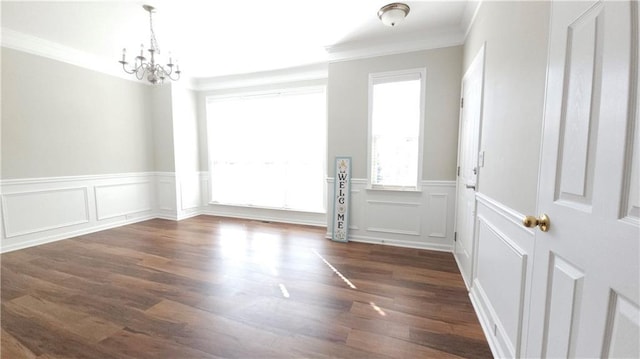 interior space with crown molding, wainscoting, a decorative wall, wood finished floors, and a chandelier