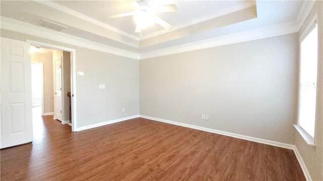 spare room featuring ceiling fan, visible vents, a raised ceiling, and dark wood-type flooring