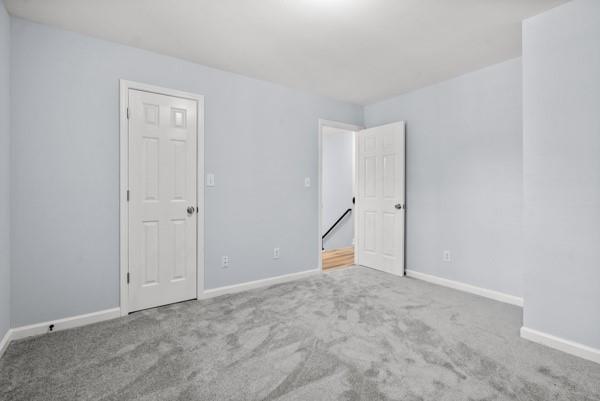 spare room featuring carpet flooring and baseboards