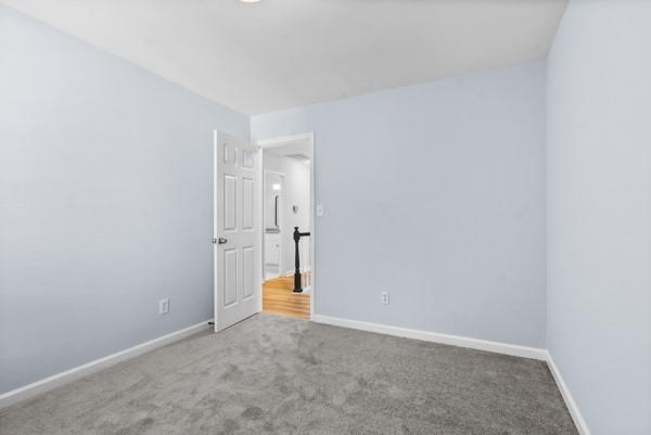 carpeted empty room featuring baseboards