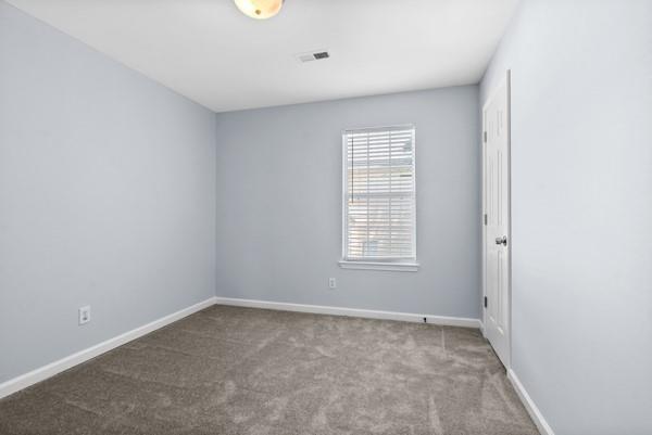 carpeted empty room featuring baseboards