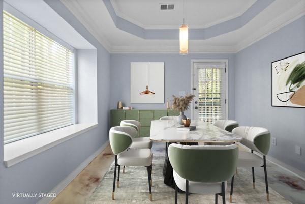 unfurnished room featuring a raised ceiling, ornamental molding, and baseboards