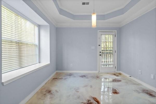 empty room with crown molding, a tray ceiling, and baseboards