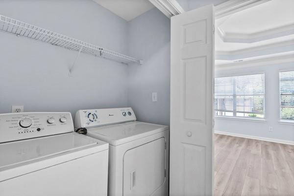 washroom featuring separate washer and dryer, light wood-type flooring, and baseboards