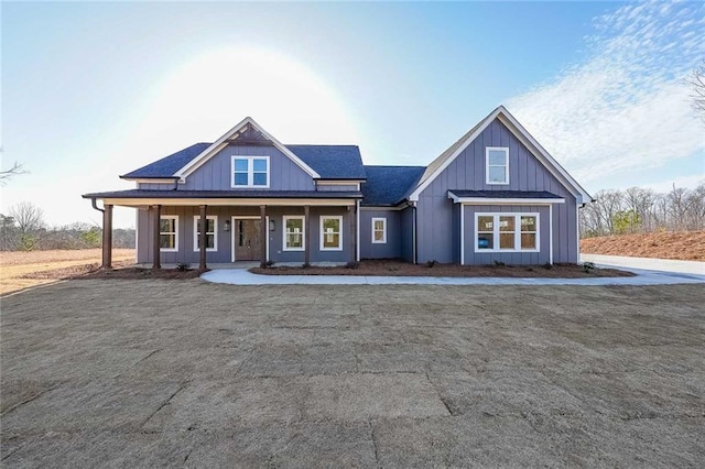 view of front of property with board and batten siding, a porch, and a shingled roof