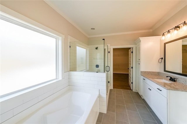 full bathroom with a garden tub, a spacious closet, a shower stall, vanity, and tile patterned flooring