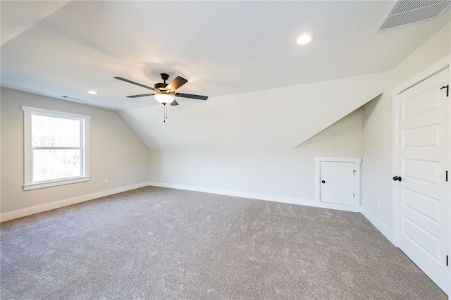 bonus room with baseboards, visible vents, vaulted ceiling, and carpet flooring