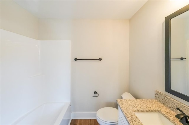 full bath with baseboards, vanity, toilet, and wood finished floors