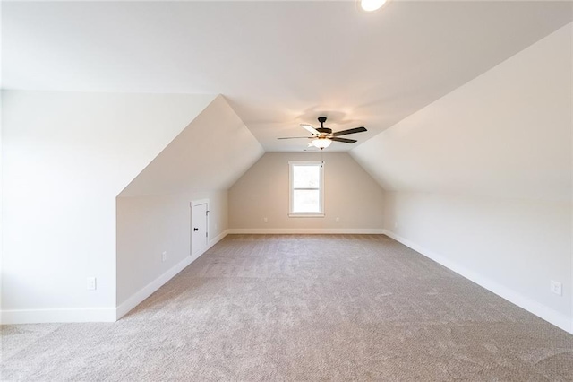 additional living space with lofted ceiling, baseboards, ceiling fan, and carpet