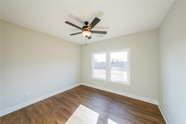 unfurnished room with visible vents, baseboards, ceiling fan, and wood finished floors