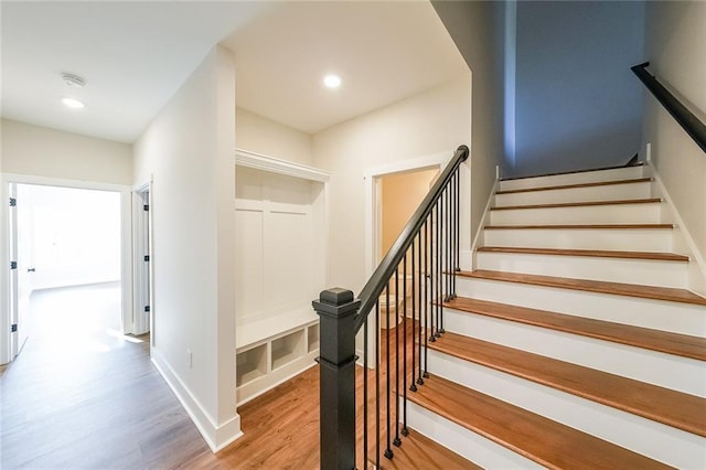 stairway featuring recessed lighting, baseboards, and wood finished floors