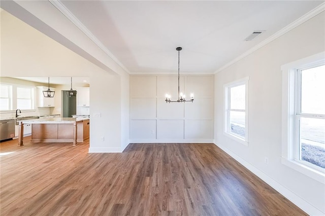 unfurnished dining area featuring a wealth of natural light, visible vents, crown molding, and a notable chandelier