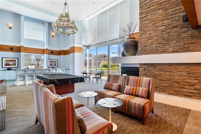 game room with a multi sided fireplace, a towering ceiling, and a notable chandelier