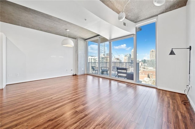 unfurnished room with a wall of windows and wood-type flooring