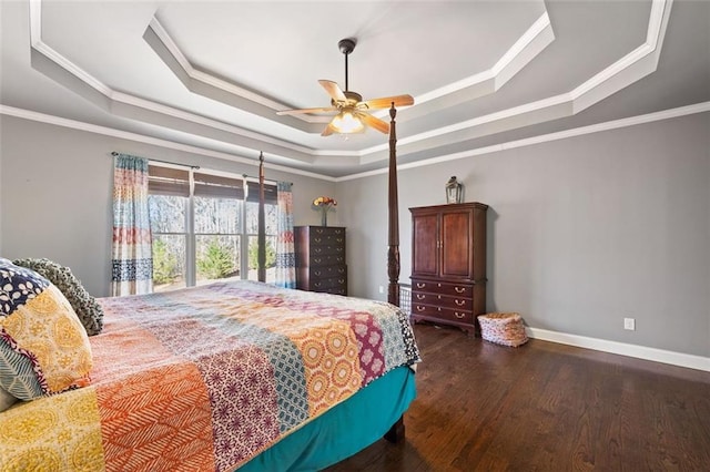 bedroom featuring ornamental molding, ceiling fan, a tray ceiling, and dark hardwood / wood-style flooring