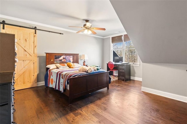 bedroom with ornamental molding, ceiling fan, a barn door, and dark wood-type flooring