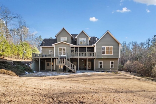 rear view of property featuring a wooden deck and a sunroom