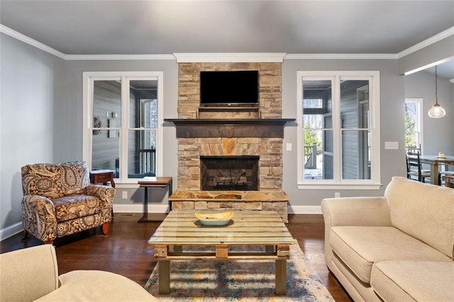 living room with ornamental molding, dark hardwood / wood-style flooring, and a stone fireplace