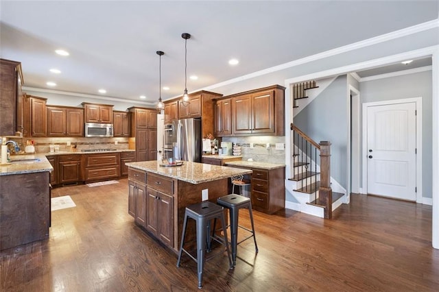 kitchen with stainless steel appliances, a kitchen island, decorative backsplash, and hanging light fixtures