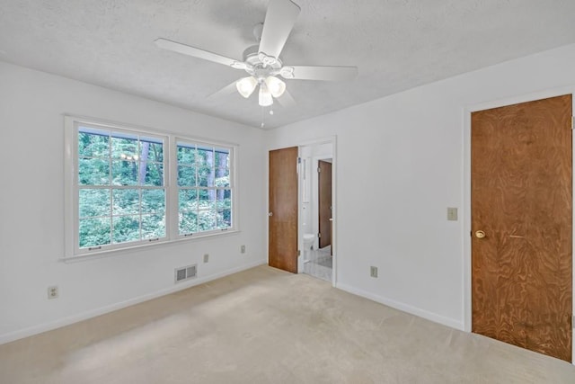 4856 Rock Haven Dr, Lilburn, GA 30047 - unfurnished bedroom featuring baseboards, light carpet, a textured ceiling, a ceiling fan, and ensuite bath