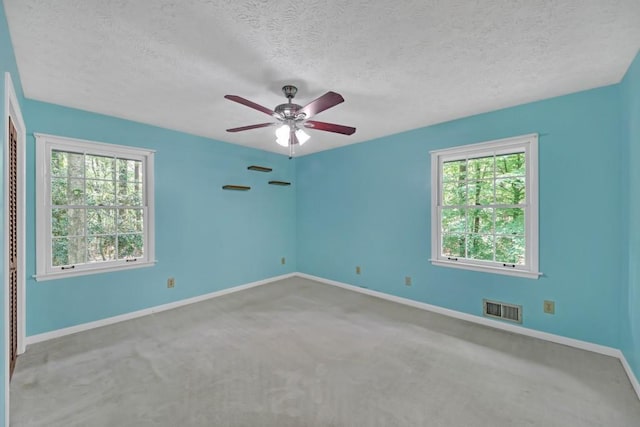 4856 Rock Haven Dr, Lilburn, GA 30047 - carpeted empty room with healthy amount of natural light, a textured ceiling, baseboards, and a ceiling fan