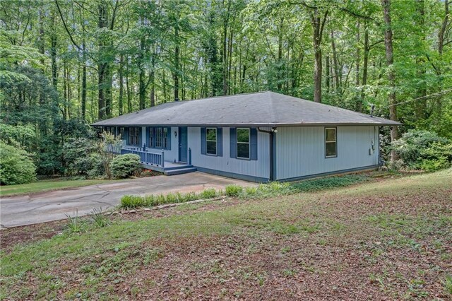 4856 Rock Haven Dr, Lilburn, GA 30047 - ranch-style house with covered porch, driveway, and a view of trees