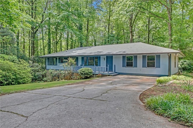 4856 Rock Haven Dr, Lilburn, GA 30047 - ranch-style house featuring a porch, driveway, and a wooded view