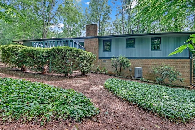 4856 Rock Haven Dr, Lilburn, GA 30047 - rear view of house with brick siding, a chimney, and cooling unit