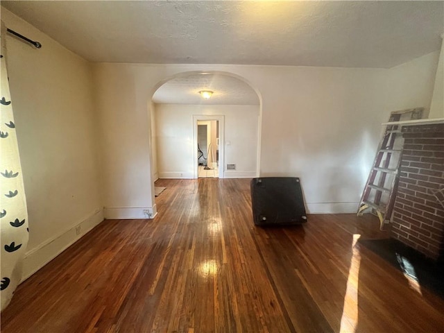 1165 Oak St SW, Atlanta, GA 30310 - unfurnished living room featuring arched walkways, hardwood / wood-style flooring, and baseboards