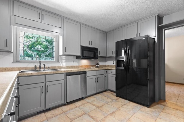 kitchen with gray cabinets, tasteful backsplash, sink, and black appliances