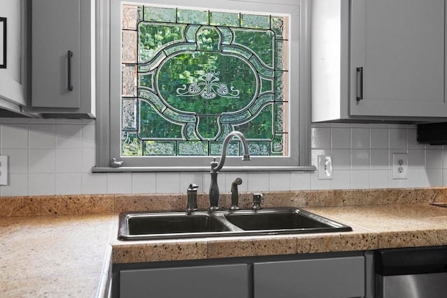 kitchen with tasteful backsplash, sink, dishwasher, and a healthy amount of sunlight