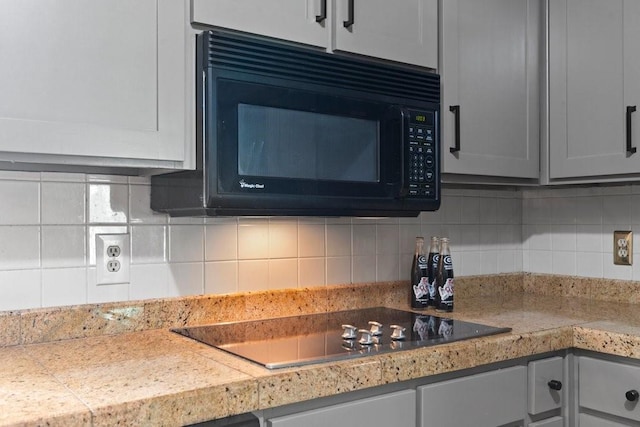 kitchen featuring decorative backsplash and black appliances